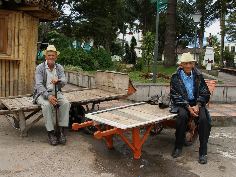Två äldre män sitter på kärror