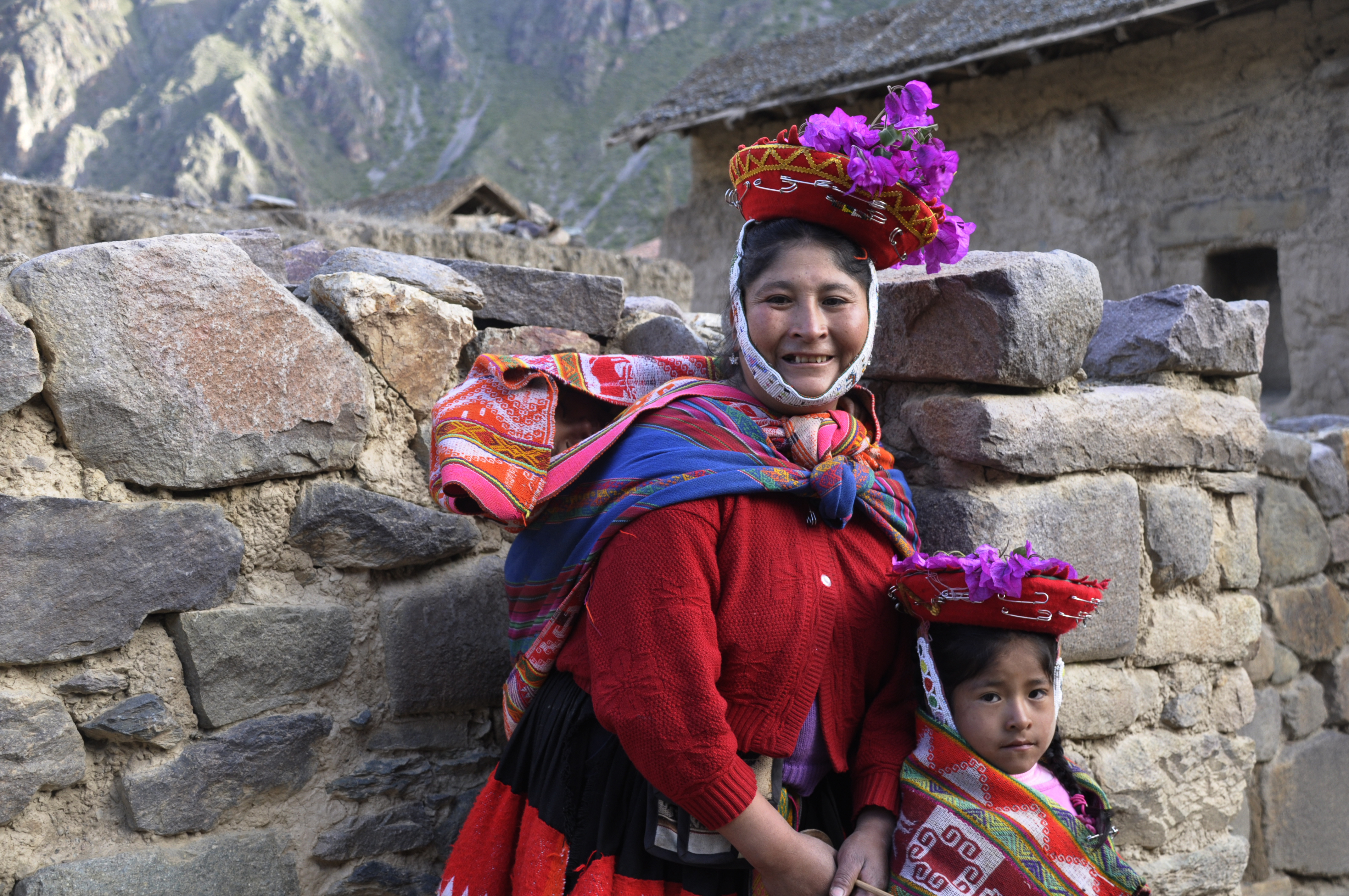 Familj röda kläder vid stenmur