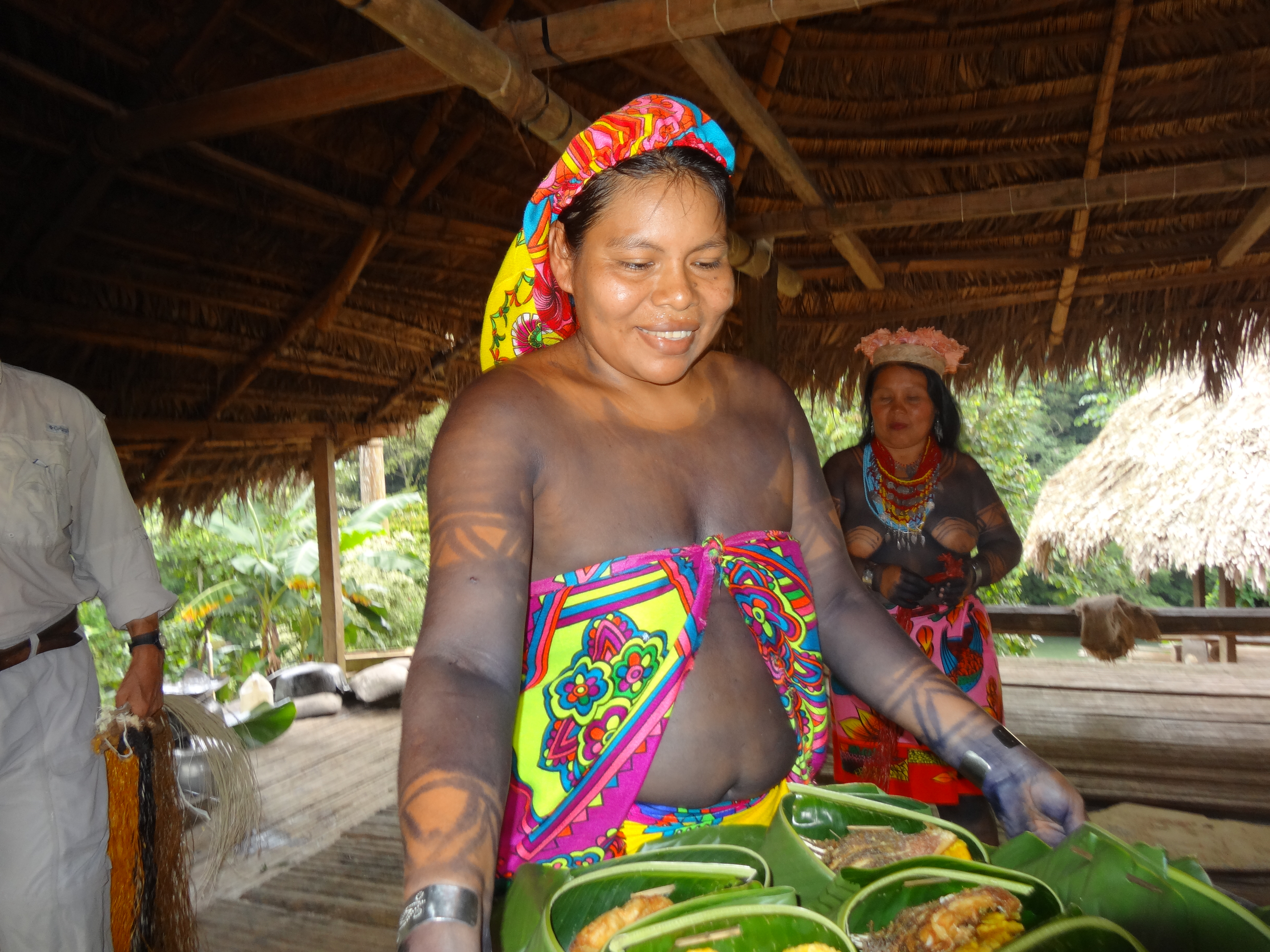 Kvinna som bär fram mat inlindat i blad.