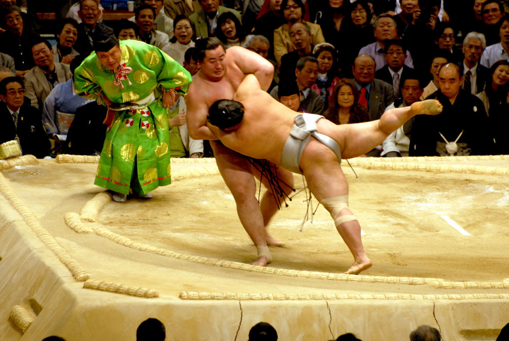 Sumo - japans nationalsport. Domaren tittar noga vem som skulle nudda på marken först eller kastas utanför ringen.