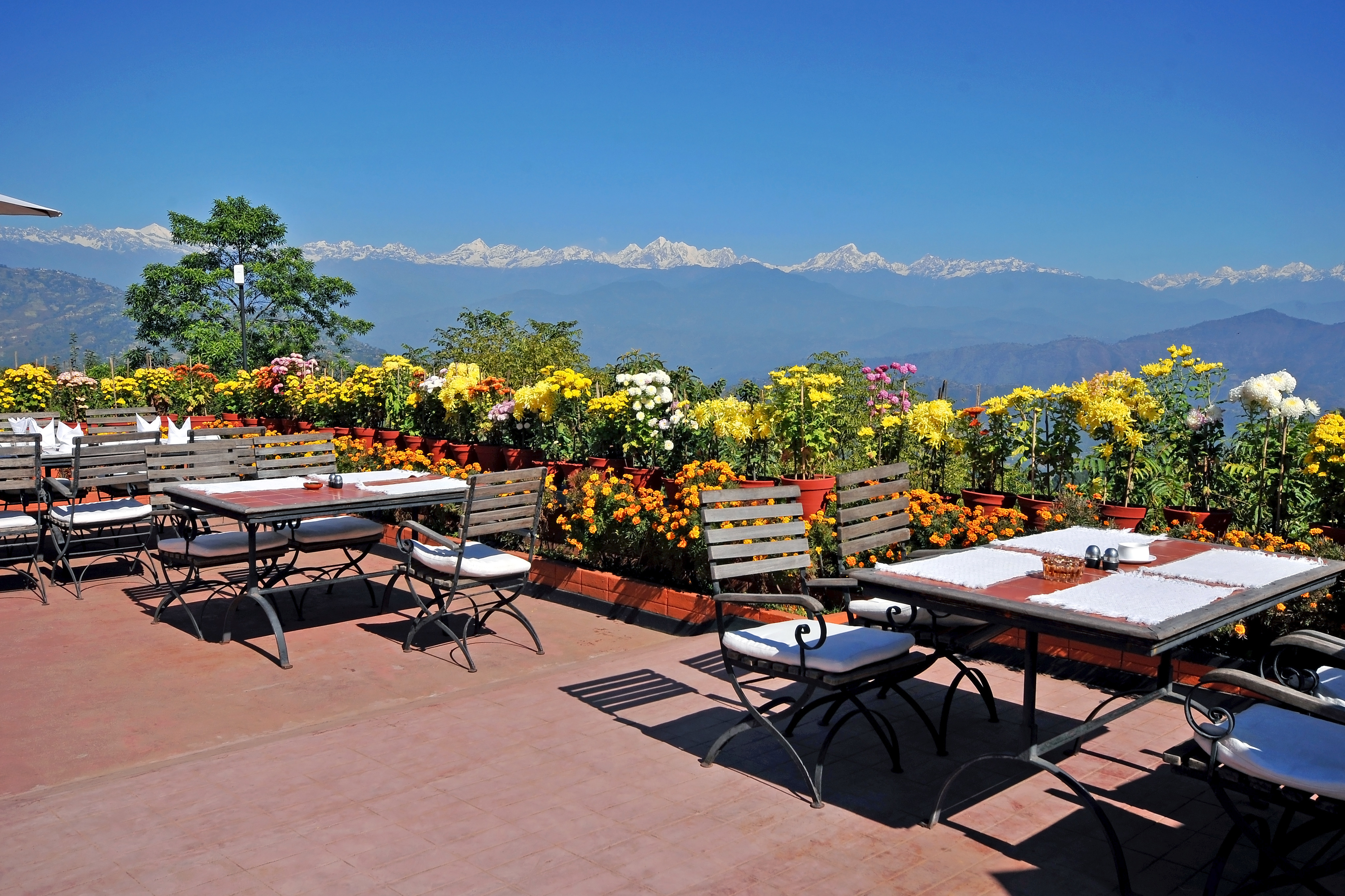 Bord i förgrunden, snöklädda berg och blå himmel