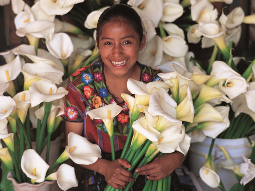 Ung kvinna säljer vita blommor i Centralamerika.