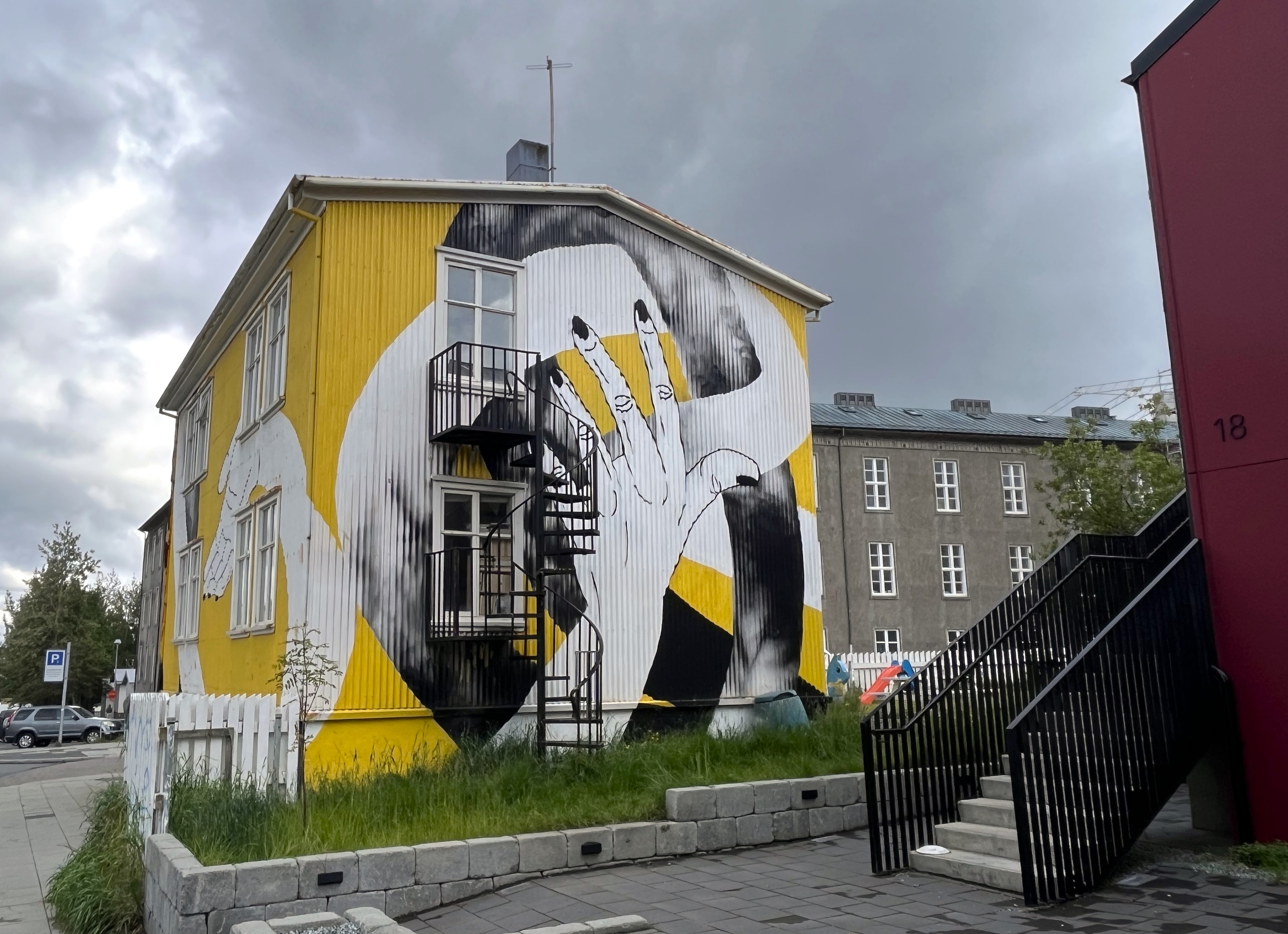 På bilden ser vi ett gult konstverk på ett hus i Reykjavik